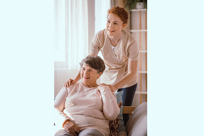 Young caregiver helping an older woman in the nursing house 